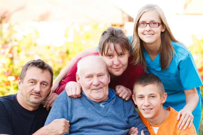 Pflegerin mit Familie im Garten – familiäre Pflege und Betreuung während der Verhinderungspflege
