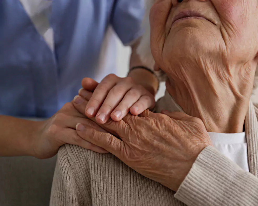 Pflegerin legt die Hand auf die Schulter einer Seniorin Pflegerin legt fürsorglich die Hand auf die Schulter einer Seniorin – Sinnbild für Zuwendung und Pflege in Dreieich